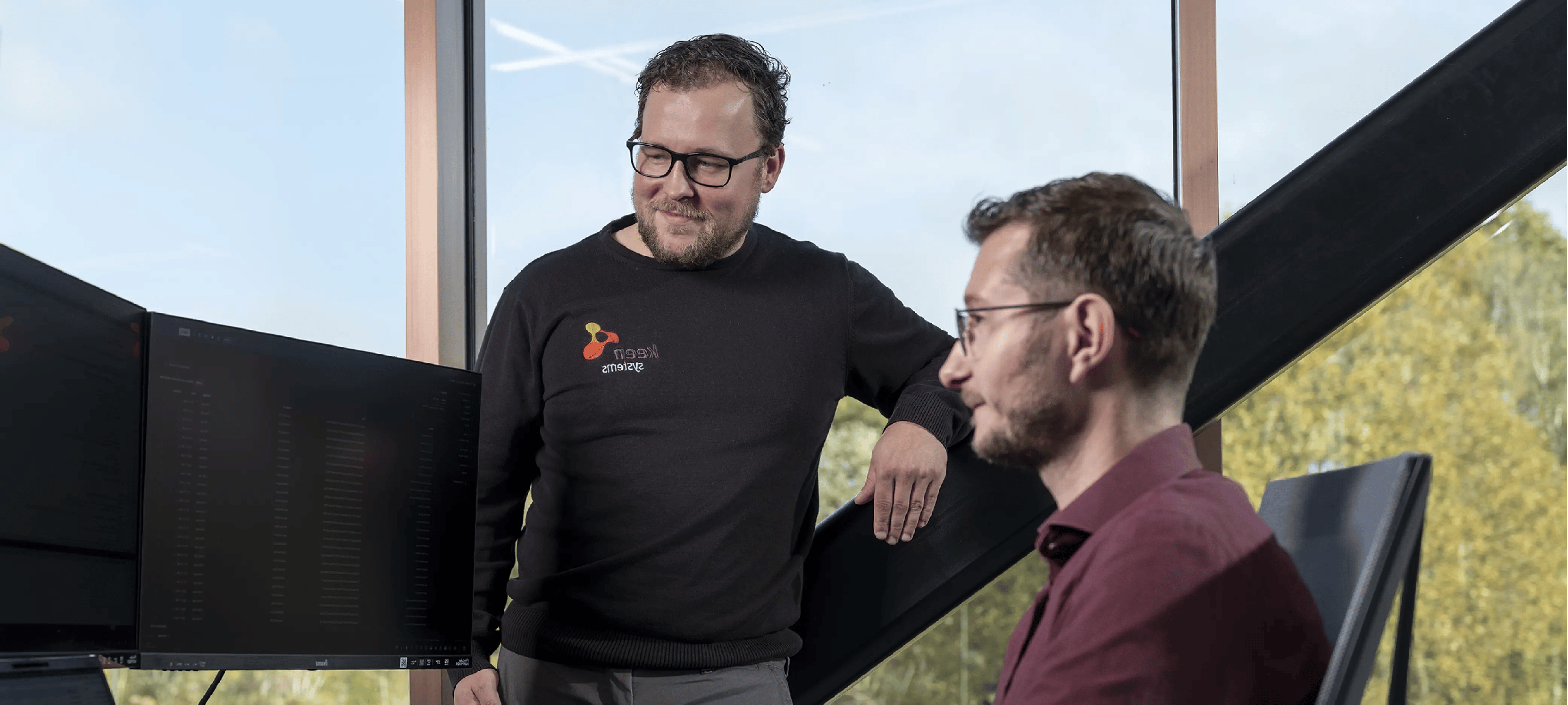 Medewerkers van KeenSystems kijken naar bureau