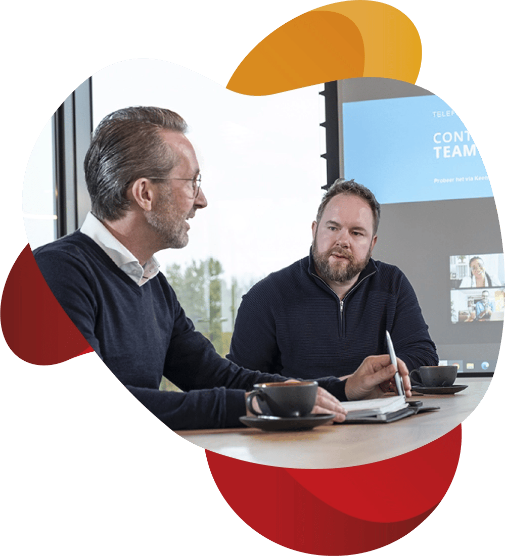 Medewerker KeenSystems kijkt naar andere medewerker die praat tijdens een overleg.