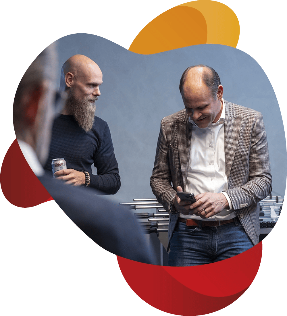 Medewerker van KeenSystems kijkt op telefoon. Foto over schouder genomden